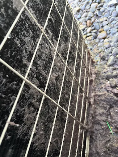 AC Equipment Protection & Maintenance - Professional Salem HVAC Service Protected AC condenser unit with security cage showing proper outdoor equipment maintenance Salem Oregon