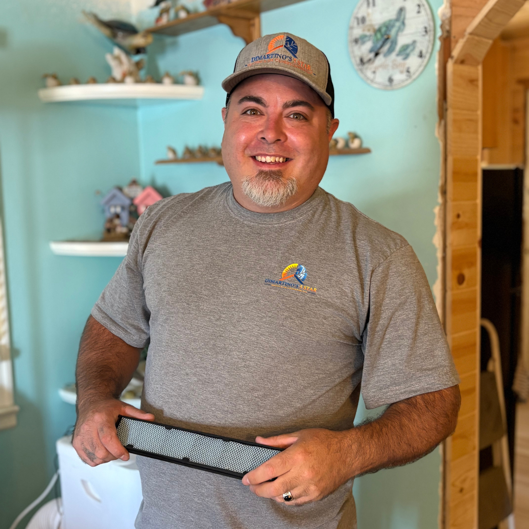 DiMartino's HVAC technician with air filter in customer home